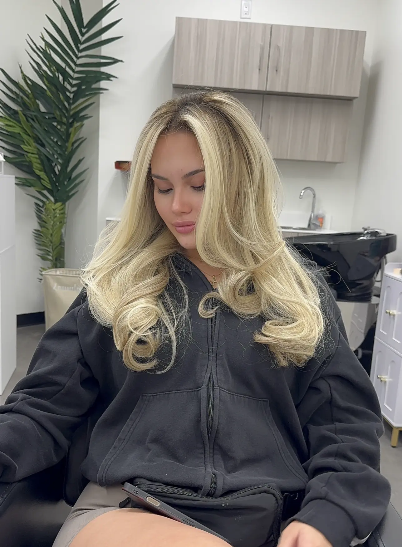 Bright blonde balayage blowout with voluminous bouncy curled ends